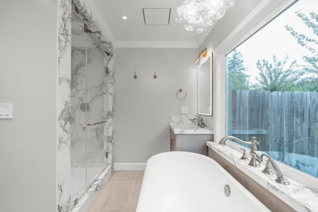a bathroom with a tub sink mirror and toilet