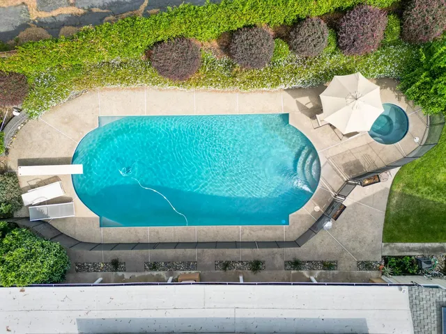 an aerial view of a house with a yard and large trees