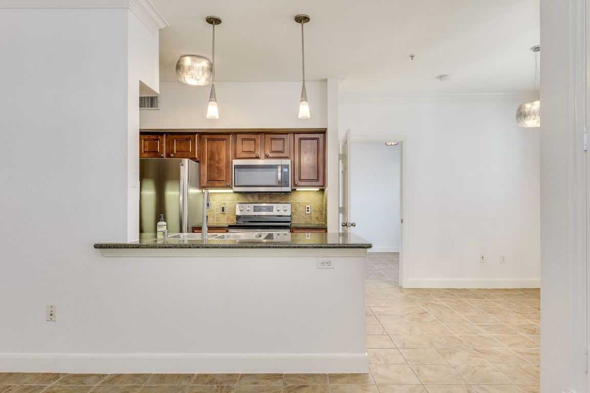 7701 Rialto Boulevard, Unit 1116 Austin, TX 78735 - Photo 11 of 26 a view of a kitchen with stainless steel appliances cabinets and a counter top space
