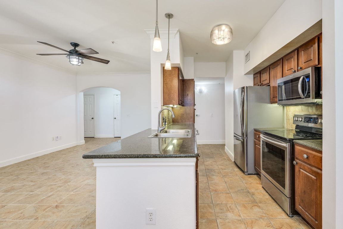 7701 Rialto Boulevard, Unit 1116 Austin, TX 78735 - Photo 12 of 26 a kitchen with stainless steel appliances granite countertop a refrigerator and a stove