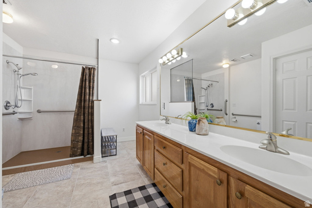 805 South River Road, Unit 70 St. George, UT 84790 - Photo 18 of 38 Bathroom featuring a double vanity with light wood cabinetry, white countertops, and dual undermount sinks