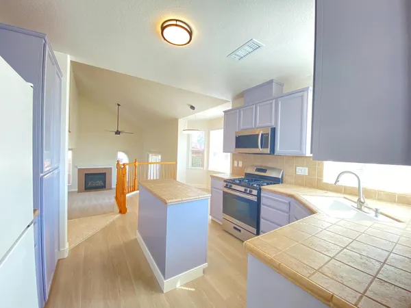 a kitchen with granite countertop a sink counter top space appliances and cabinets