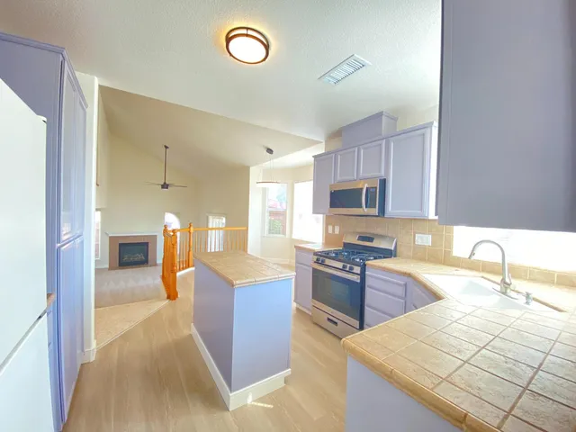 a kitchen with granite countertop a sink counter top space appliances and cabinets