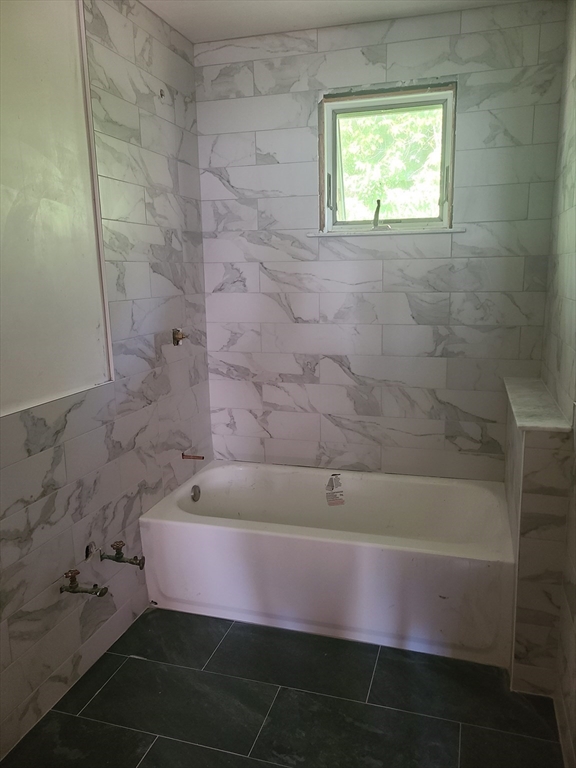 28 Tip Top Street, Unit 1 Boston, MA 02135 - Photo 4 of 13 a bathroom with a granite countertop sink and a bathtub