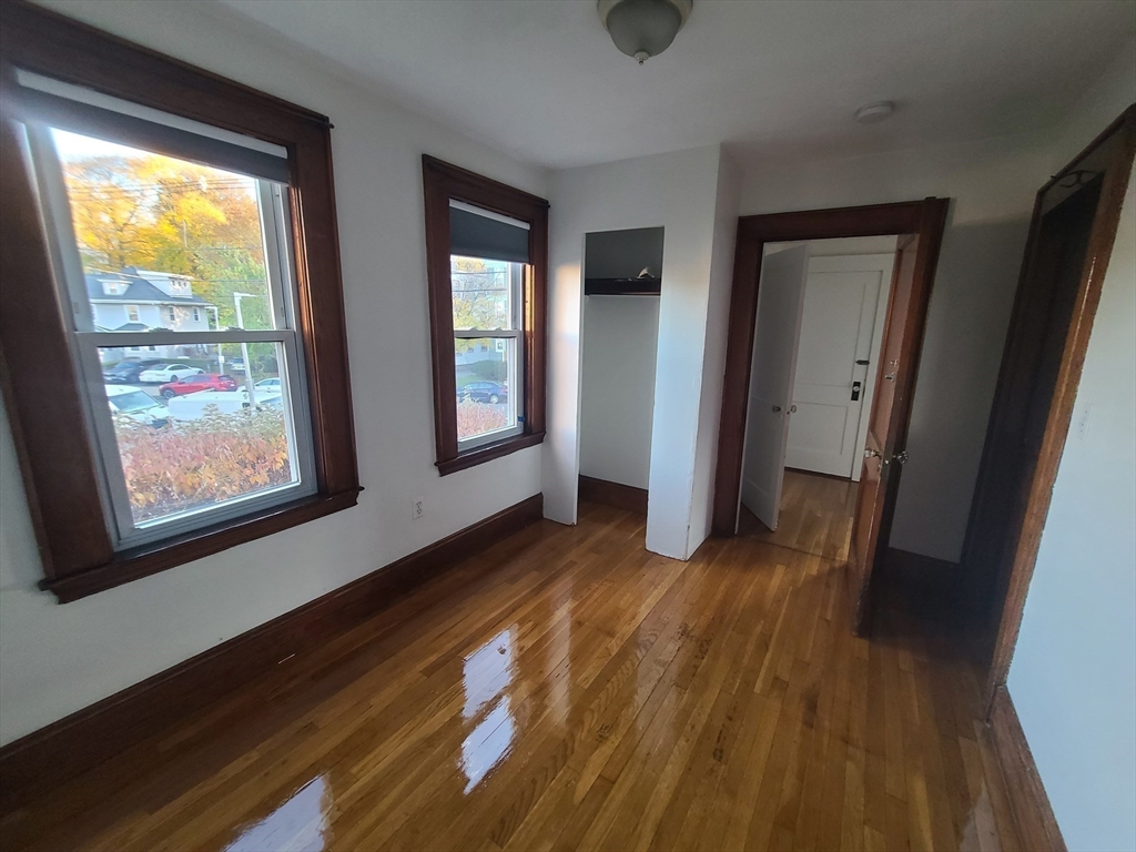 28 Tip Top Street, Unit 1 Boston, MA 02135 - Photo 6 of 13 a view of an empty room with wooden floor and a window