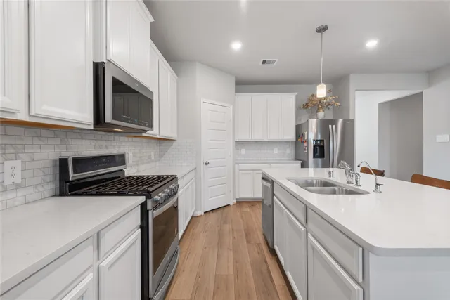 a kitchen with a sink stove and microwave