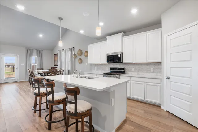 a kitchen with appliances a sink and cabinets