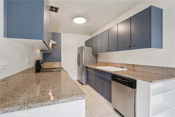 a kitchen with granite countertop a sink and a stove