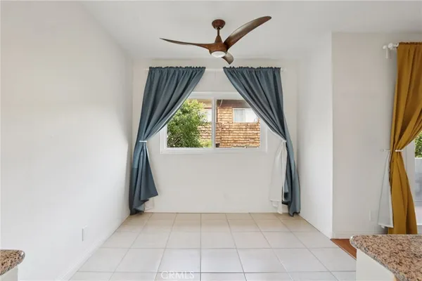 an empty room with windows and a chandelier fan