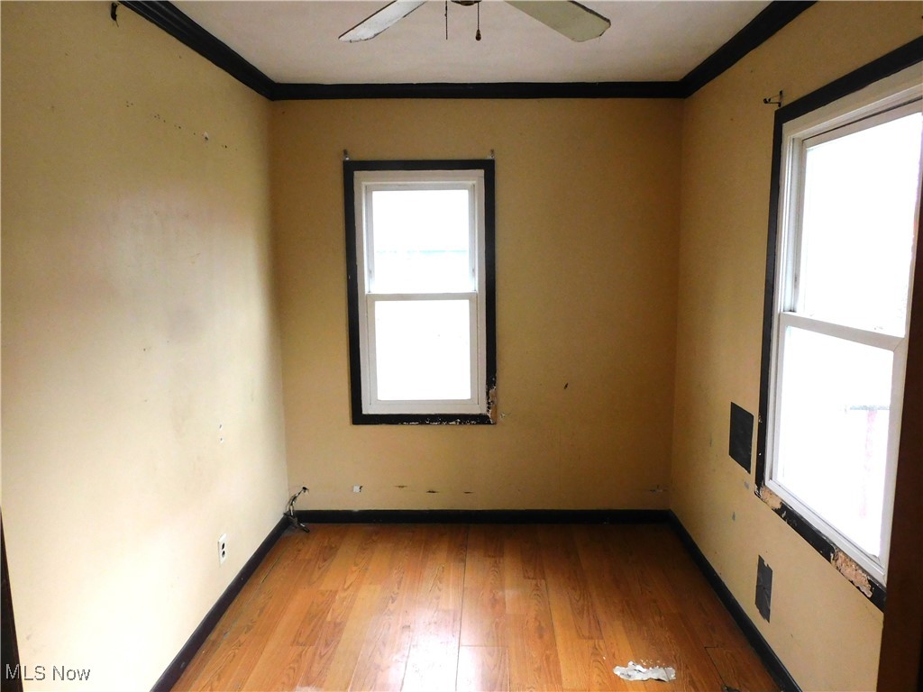 6244 North Ridge Road West Geneva, OH 44041 - Photo 15 of 15 Bedroom 2 with ornamental molding, baseboards, ceiling fan, and light wood finished floors