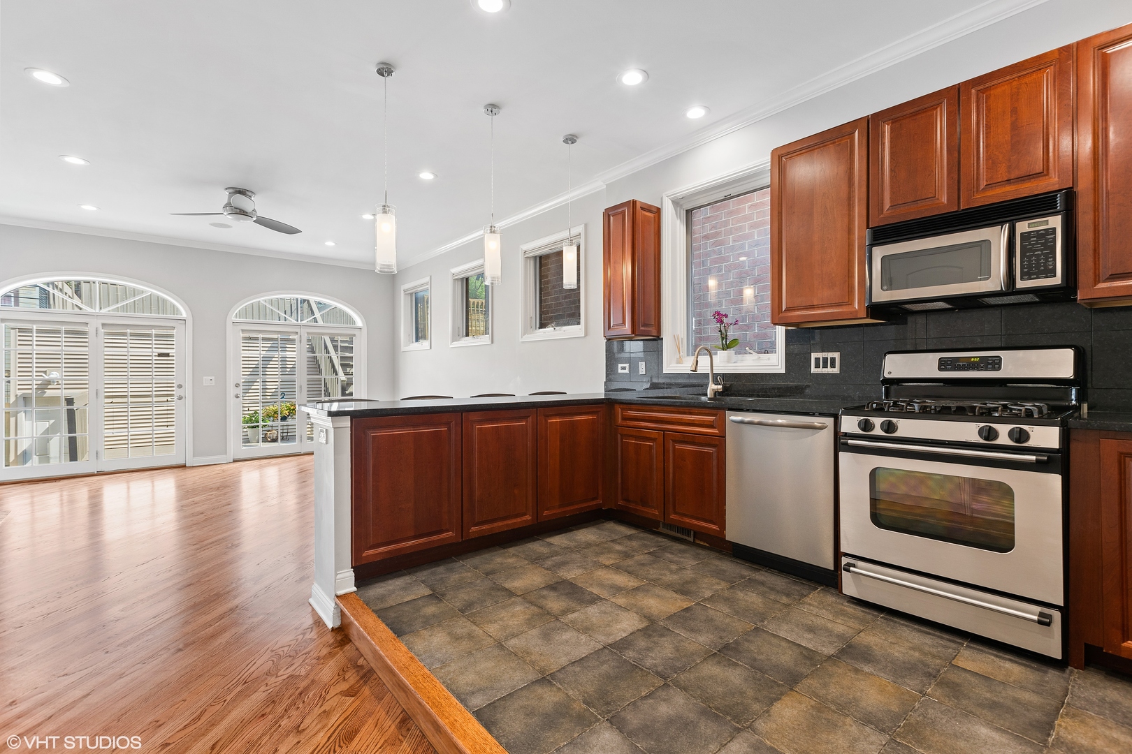 2038 West Race Avenue Chicago, IL 60612 - Photo 6 of 35 a kitchen with stainless steel appliances granite countertop a stove a sink dishwasher a microwave oven with cabinets and wooden floor