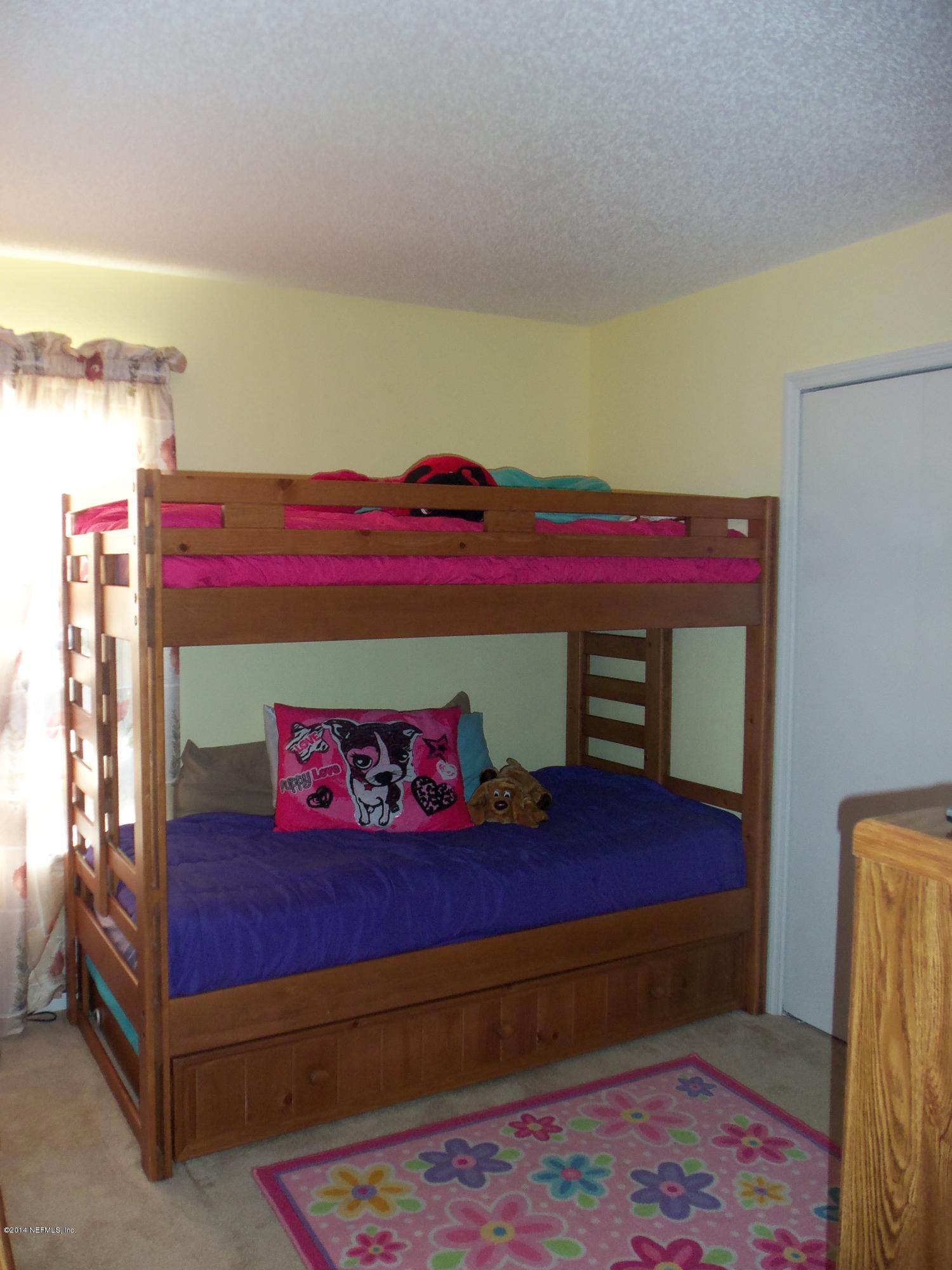 9732 Chirping Way Jacksonville, FL 32222 - Photo 11 of 27 a bedroom with a bed and a dresser