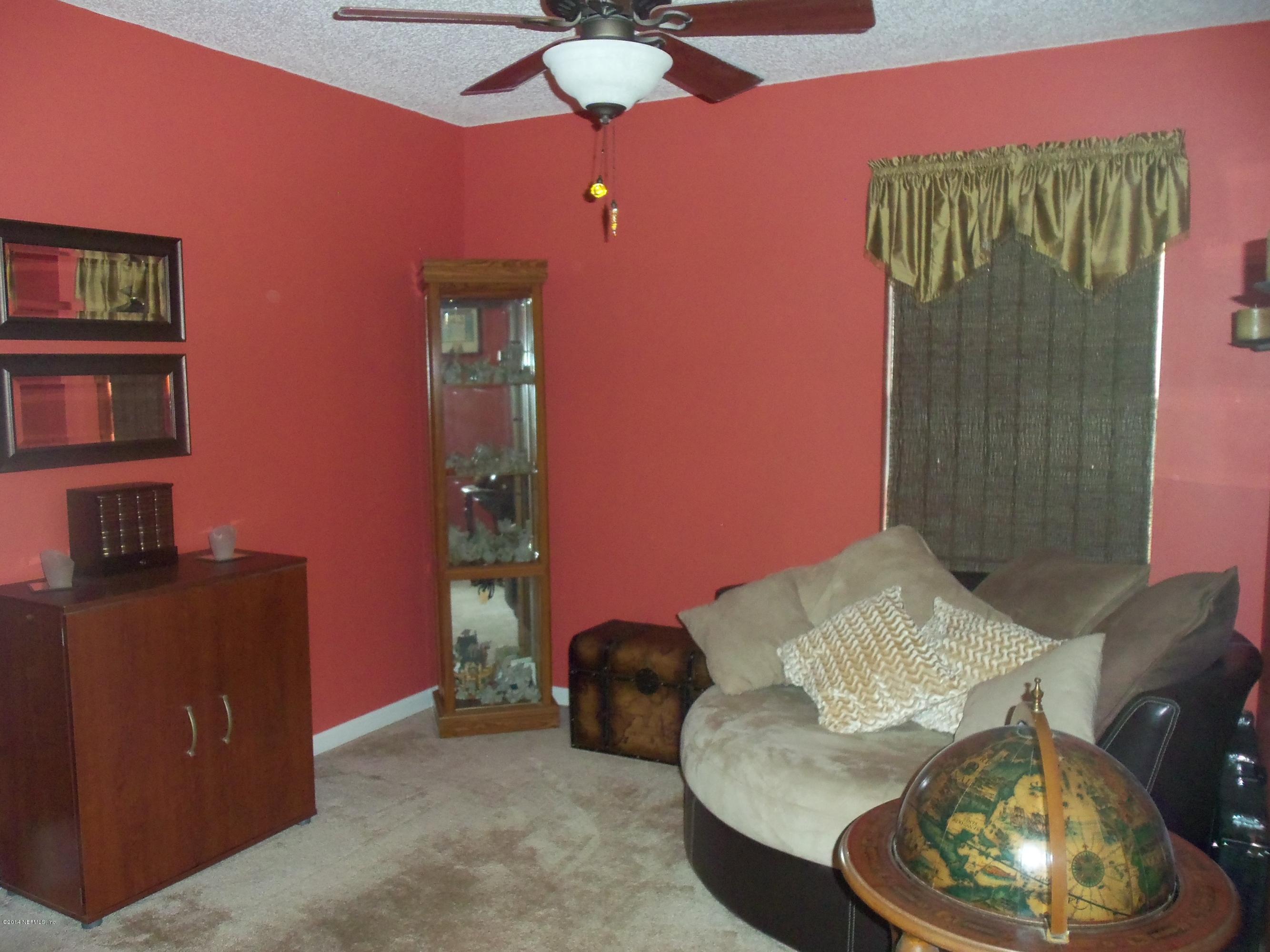 9732 Chirping Way Jacksonville, FL 32222 - Photo 12 of 27 a living room with furniture and a lamp
