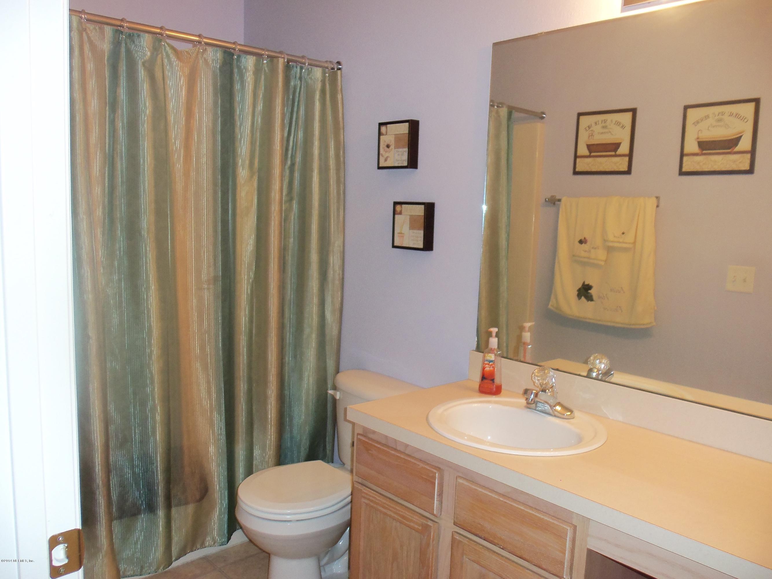 9732 Chirping Way Jacksonville, FL 32222 - Photo 14 of 27 a bathroom with a sink toilet and a mirror