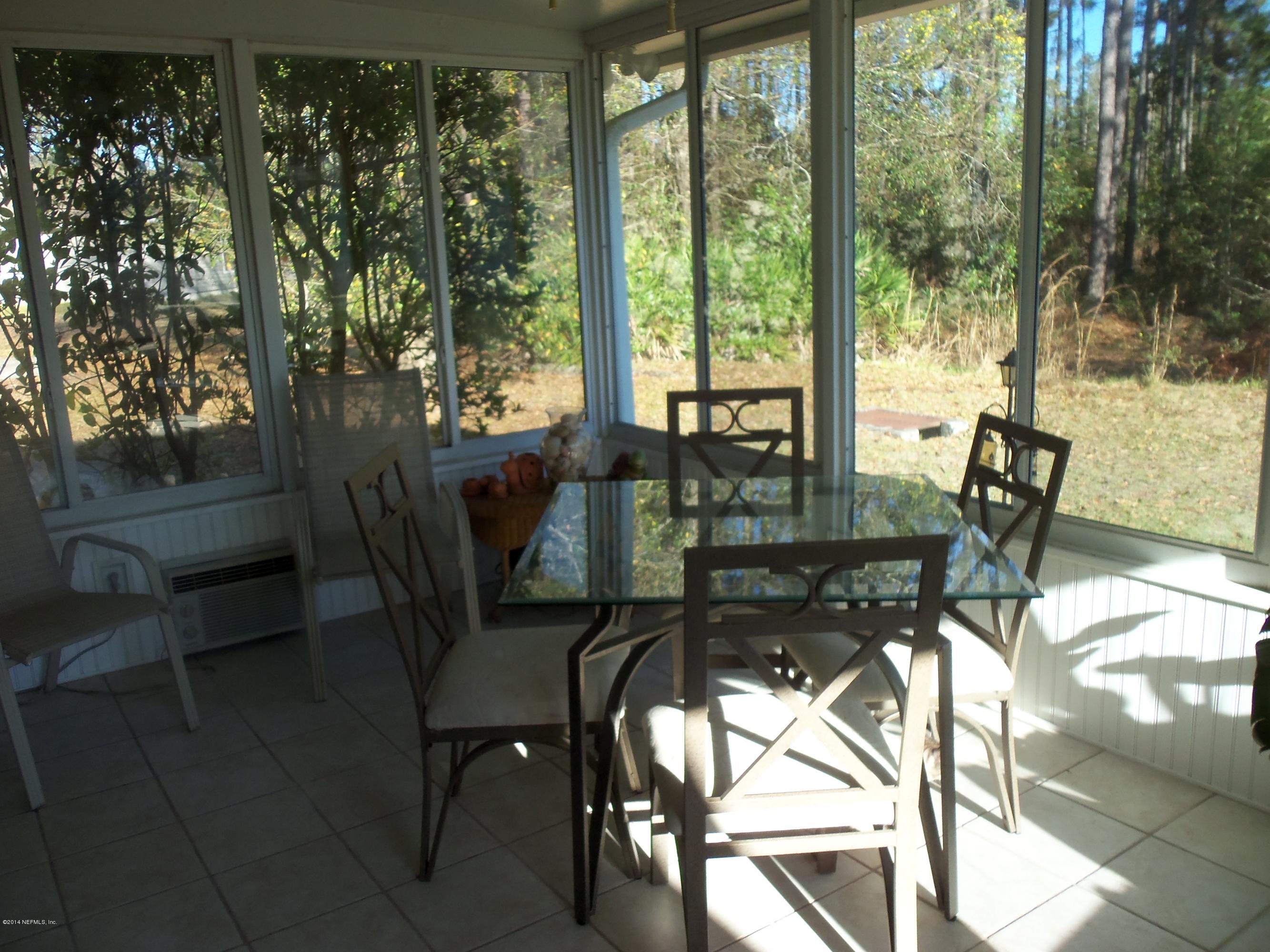 9732 Chirping Way Jacksonville, FL 32222 - Photo 19 of 27 a dining room with furniture and floor to ceiling window