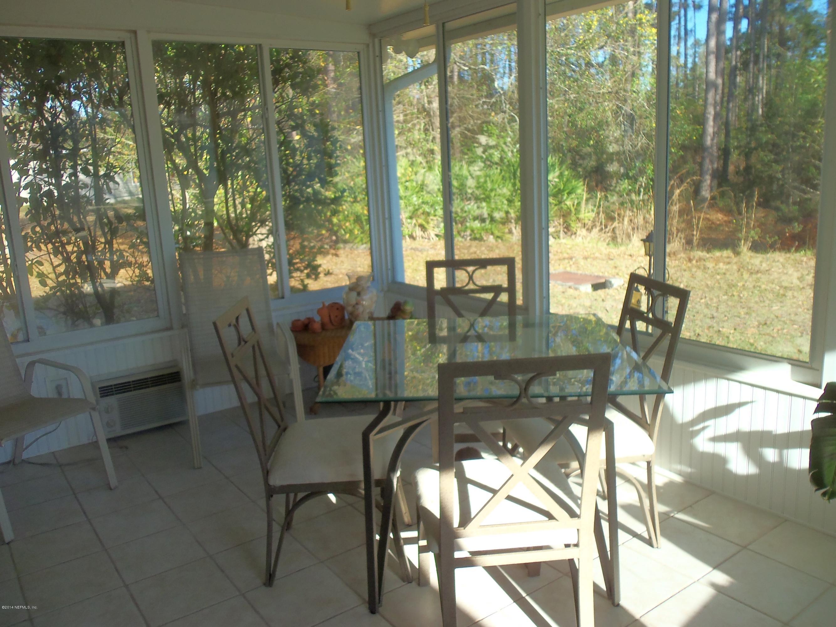 9732 Chirping Way Jacksonville, FL 32222 - Photo 20 of 27 a dining room with furniture and floor to ceiling windows