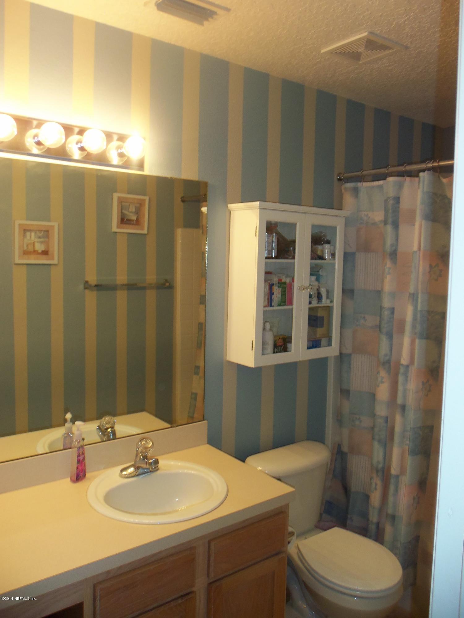 9732 Chirping Way Jacksonville, FL 32222 - Photo 22 of 27 a bathroom with a sink a toilet and shower