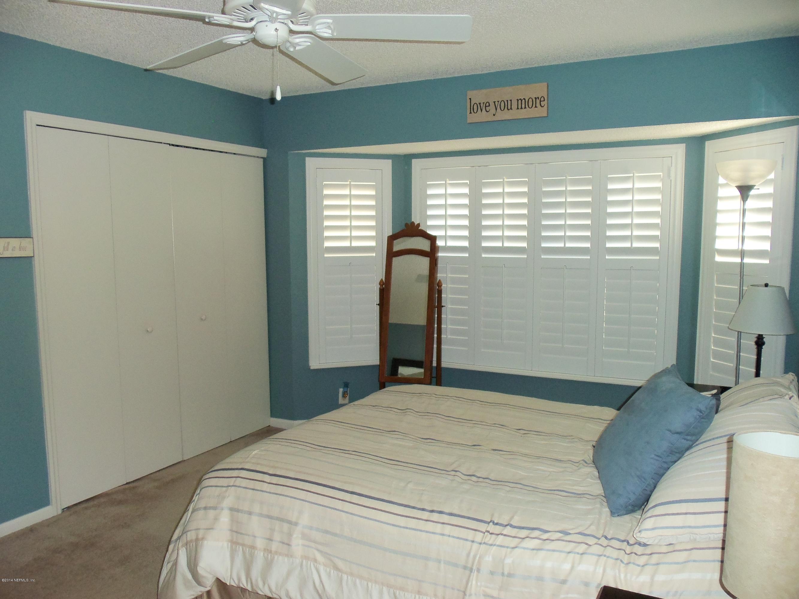 9732 Chirping Way Jacksonville, FL 32222 - Photo 25 of 27 a bedroom with a large bed and a chandelier