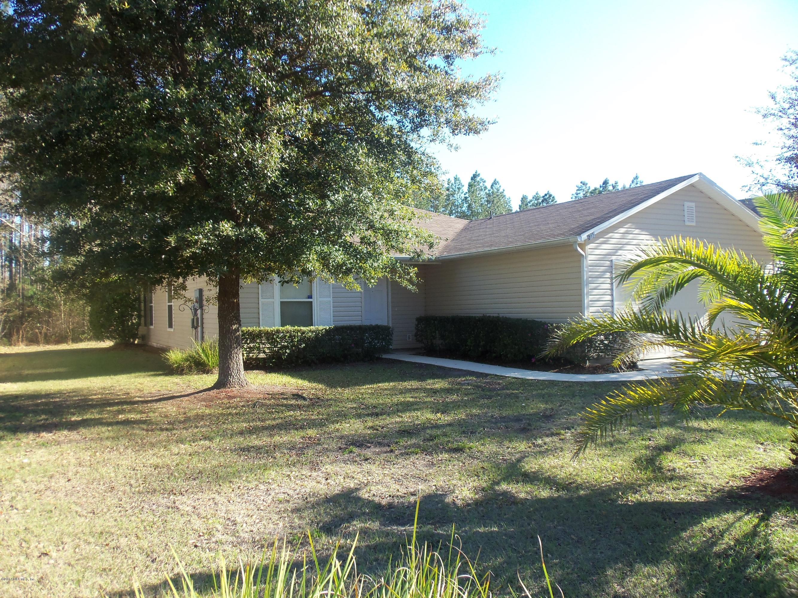 9732 Chirping Way Jacksonville, FL 32222 - Photo 5 of 27 a view of a house with a yard and garage