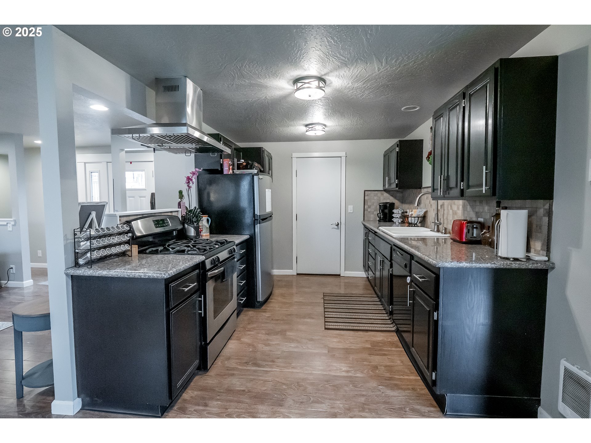 732 53rd Street Springfield, OR 97478 - Photo 8 of 27 a large kitchen with stainless steel appliances kitchen island granite countertop a stove refrigerator and a fireplace