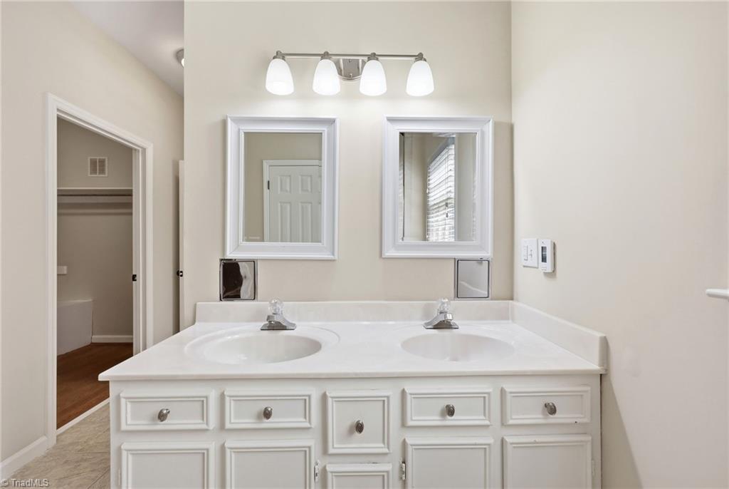 8861 Boylston Road Colfax, NC 27235 - Photo 20 of 50 Spacious primary bathroom featuring dual vanities, abundant storage, and direct access to the walk-in closet.
