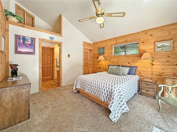 a bedroom with a bed dresser and a large window