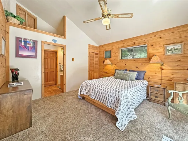 a bedroom with a bed dresser and a large window