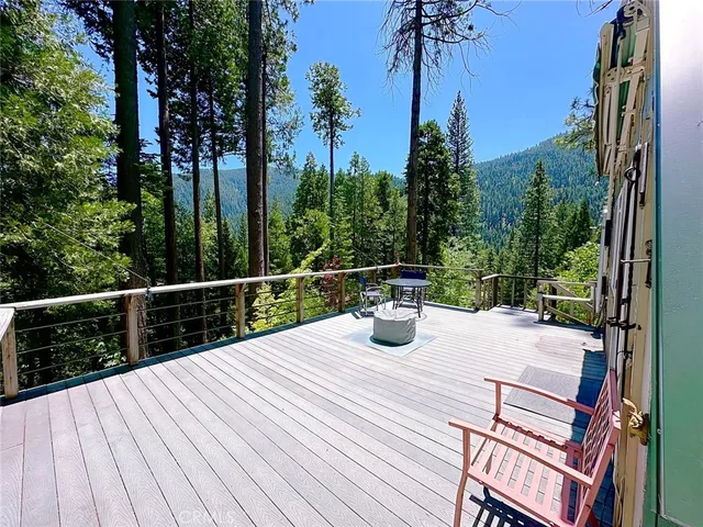 a view of a roof deck with wooden floor and palm trees
