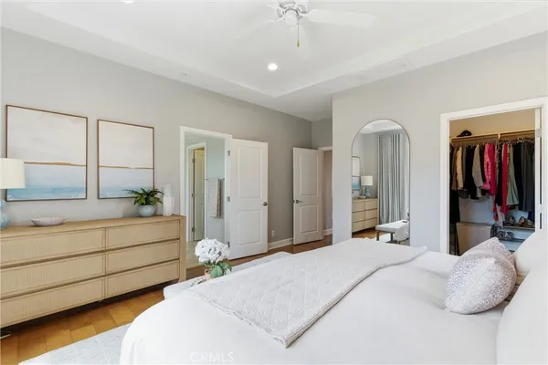 a spacious bedroom with a bed and a dresser