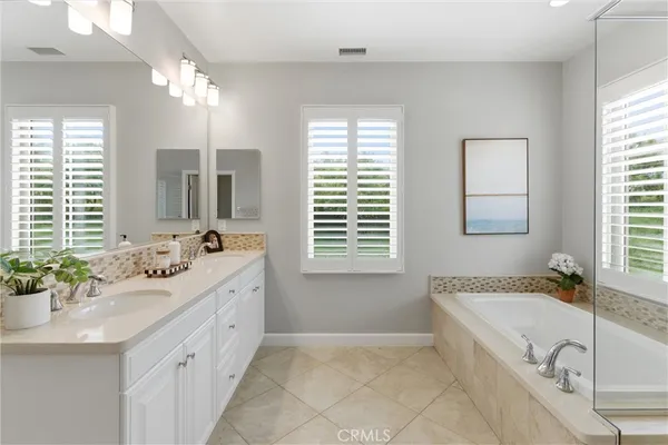 a spacious bathroom with a granite countertop tub sink and mirror