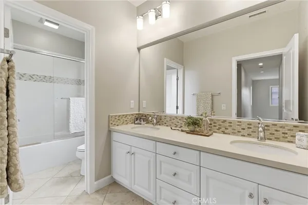 a bathroom with a granite countertop sink mirror bathtub and toilet
