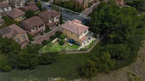 an aerial view of residential houses with outdoor space and trees