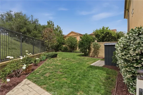 a view of a backyard with potted plants and large trees