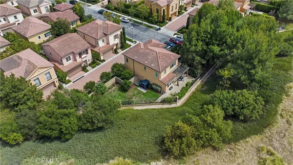 an aerial view of residential houses with outdoor space and trees all around