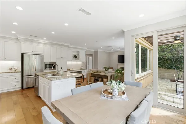 a large kitchen with sink a refrigerator and chairs