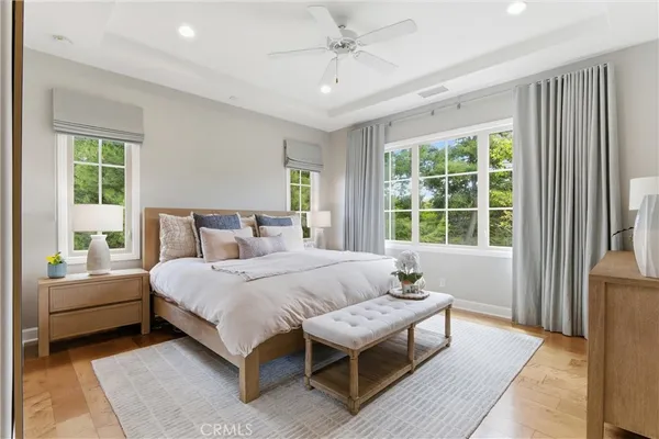 a bedroom with a bed couch and windows