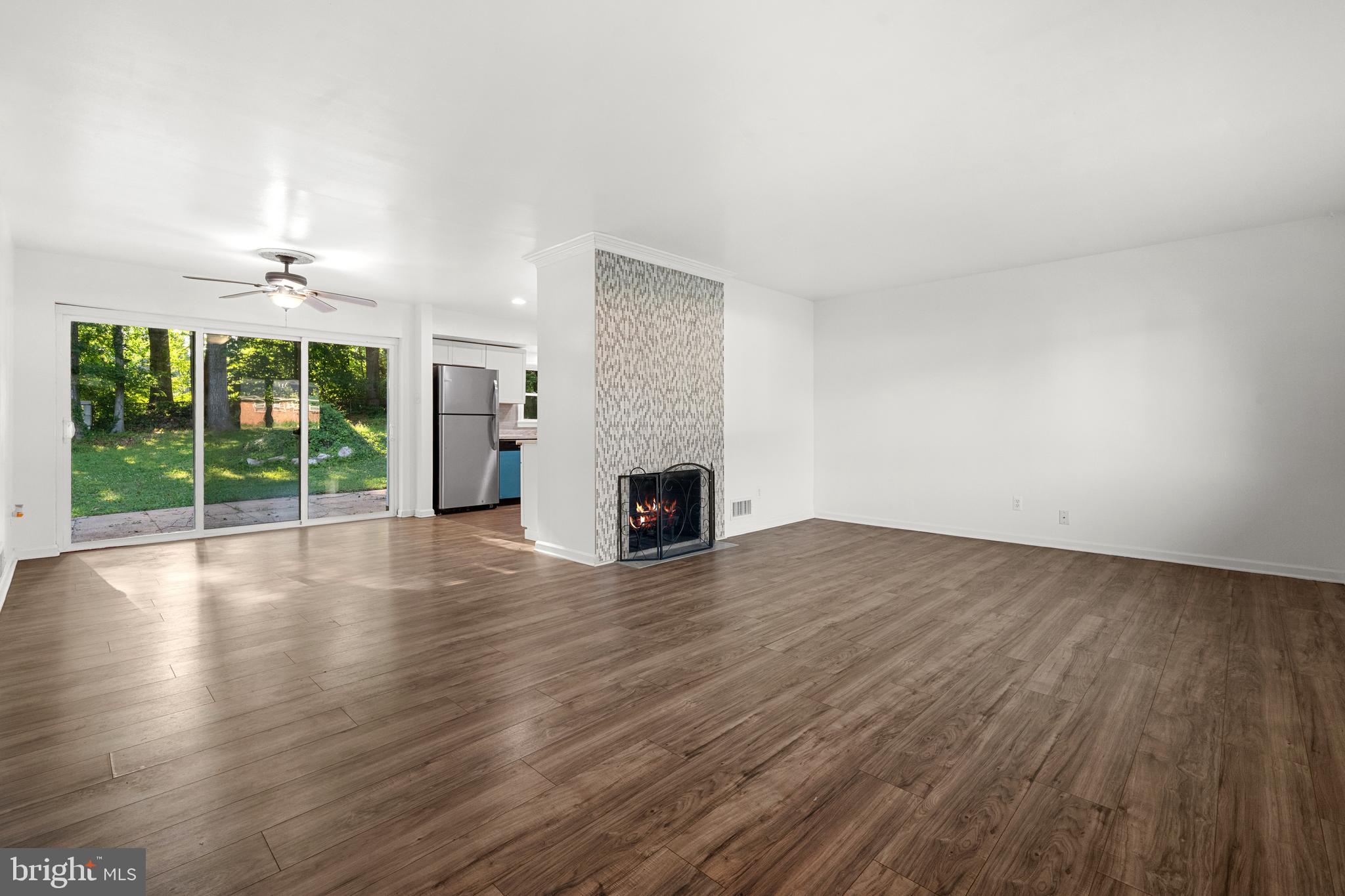 5505 Heming Avenue Springfield, VA 22151 - Photo 5 of 37 an empty room with wooden floor fireplace and windows