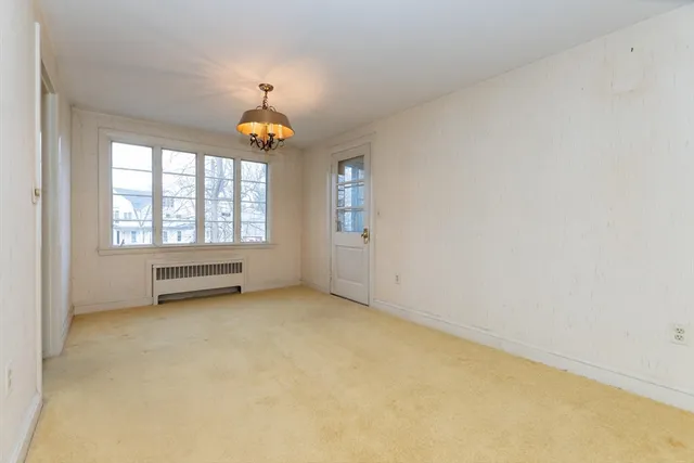 an empty room with windows and ceiling fan