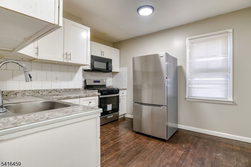 412 South 7th Street, Unit 1 Newark, NJ 07103 - Photo 2 of 11 a kitchen with granite countertop a refrigerator stove and sink
