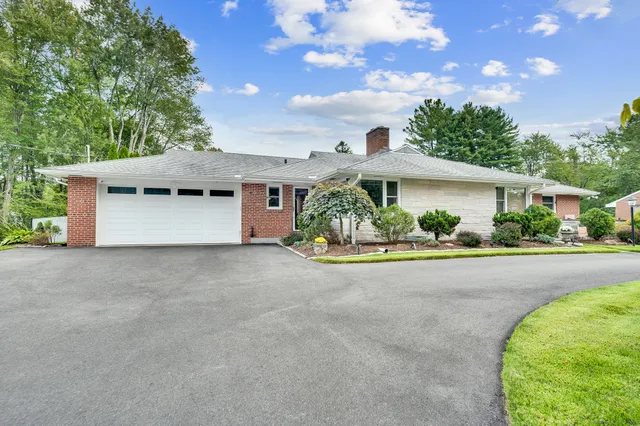 a white house with a large tree in front of it