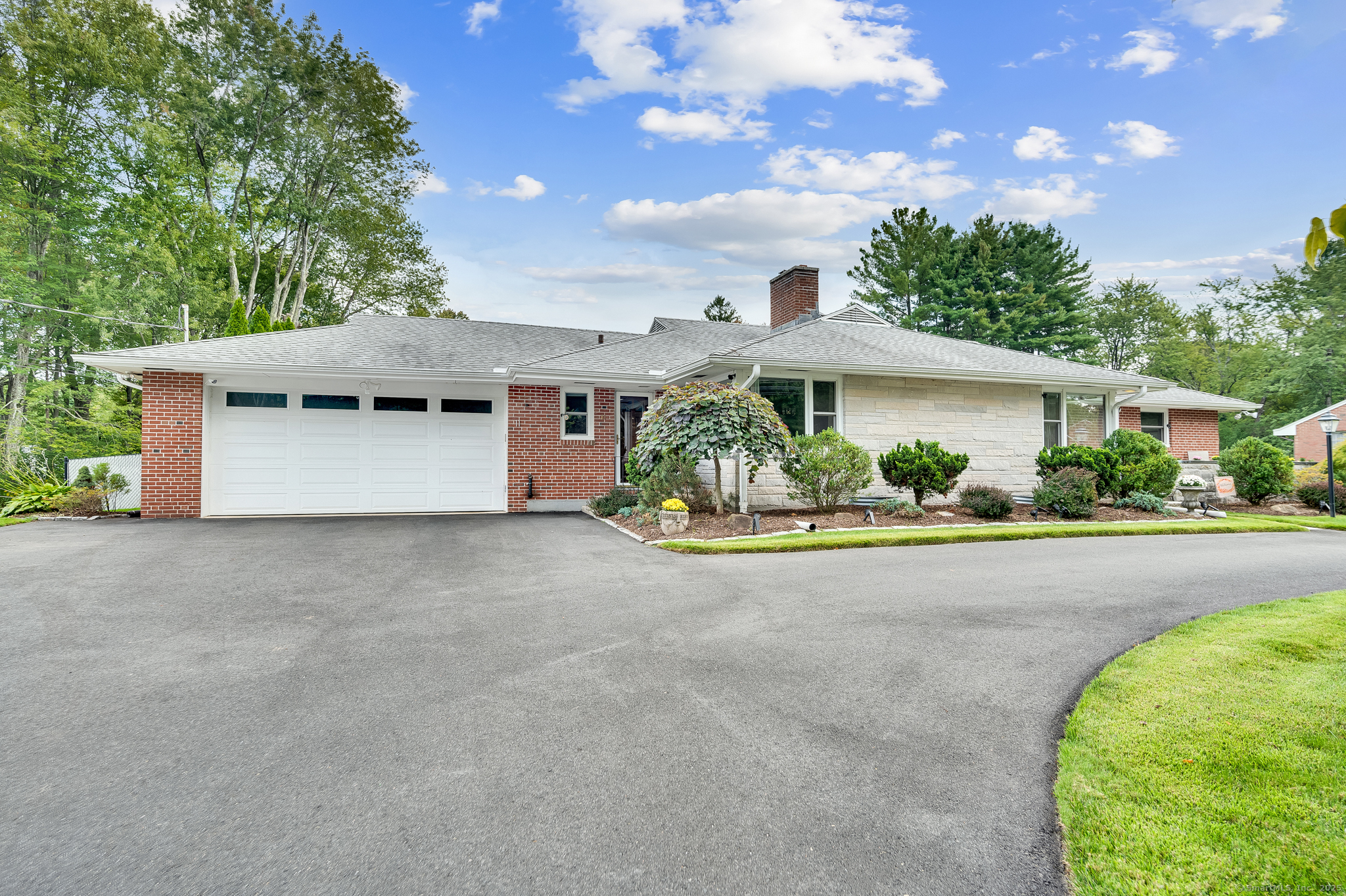 a white house with a large tree in front of it