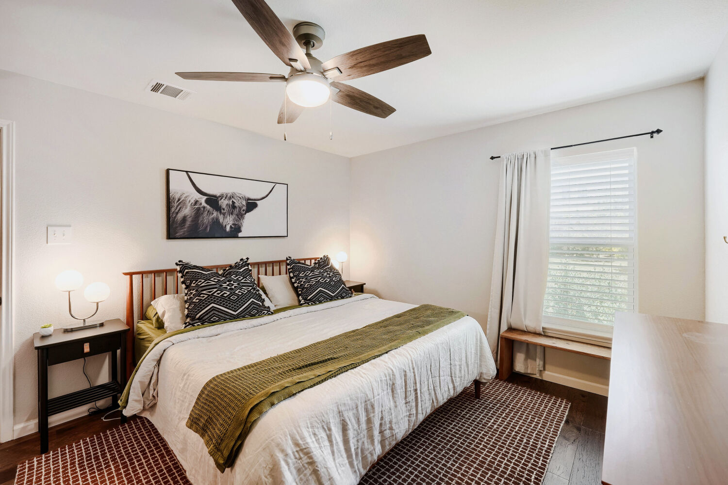 116 Millers Loop Jarrell, TX 76537 - Photo 12 of 23 The spacious primary bedroom features beautiful hardwood floors and a ceiling fan, creating a comfortable and relaxing retreat.