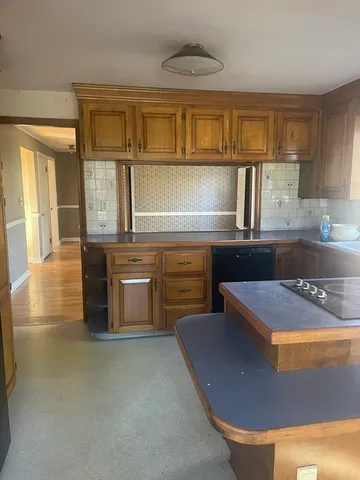 a kitchen with kitchen island granite countertop a sink cabinets and stainless steel appliances