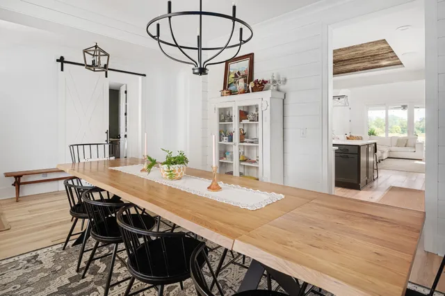 a kitchen with stainless steel appliances granite countertop a table chairs and a refrigerator