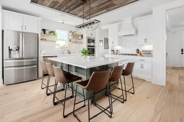 a kitchen with a table chairs and white cabinets