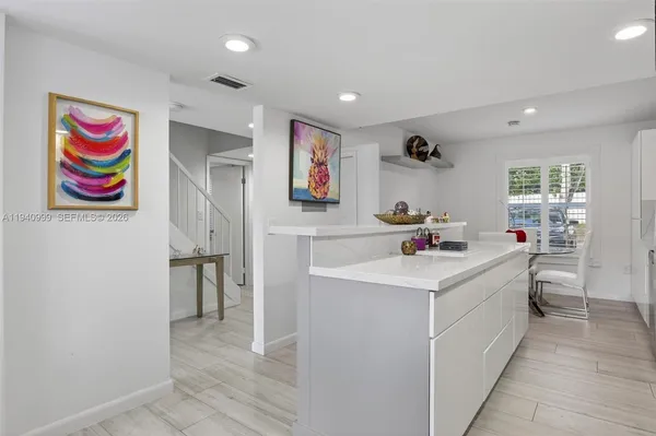 a kitchen with cabinets and wooden floor