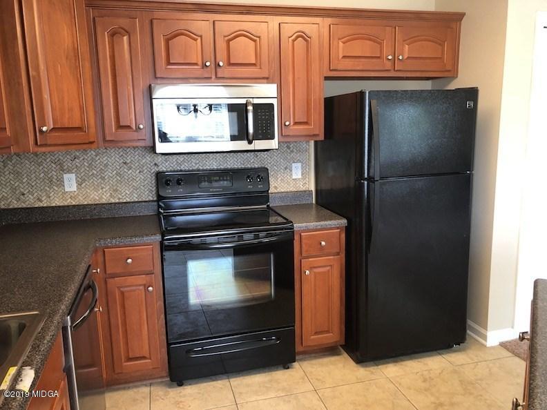 443 Bob White Road Macon, GA 31216 - Photo 6 of 7 a kitchen with granite countertop white cabinets and stainless steel appliances