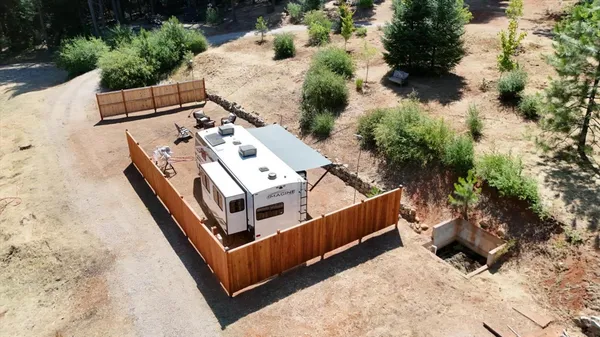 an aerial view of a house with a yard and large trees