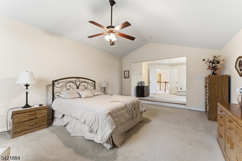 26 Rouser Way Hillsborough, NJ 08844 - Photo 31 of 49 a spacious bedroom with a bed a chandelier and a flat screen television