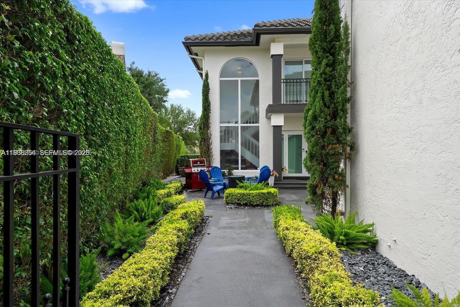 22818 El Dorado Drive Boca Raton, FL 33433 - Photo 3 of 37 a view of a house with a small yard and flower plants